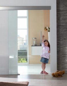 Young girl standing in doorway of a glass sliding door